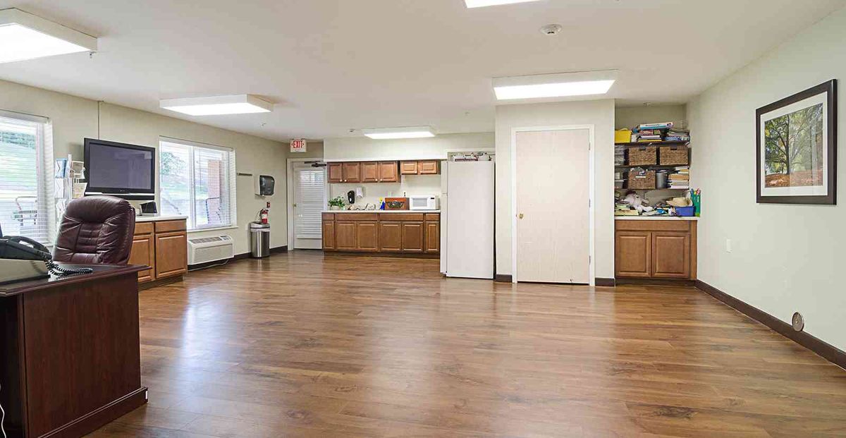 Spacious kitchen area with wooden cabinets and flooring.
