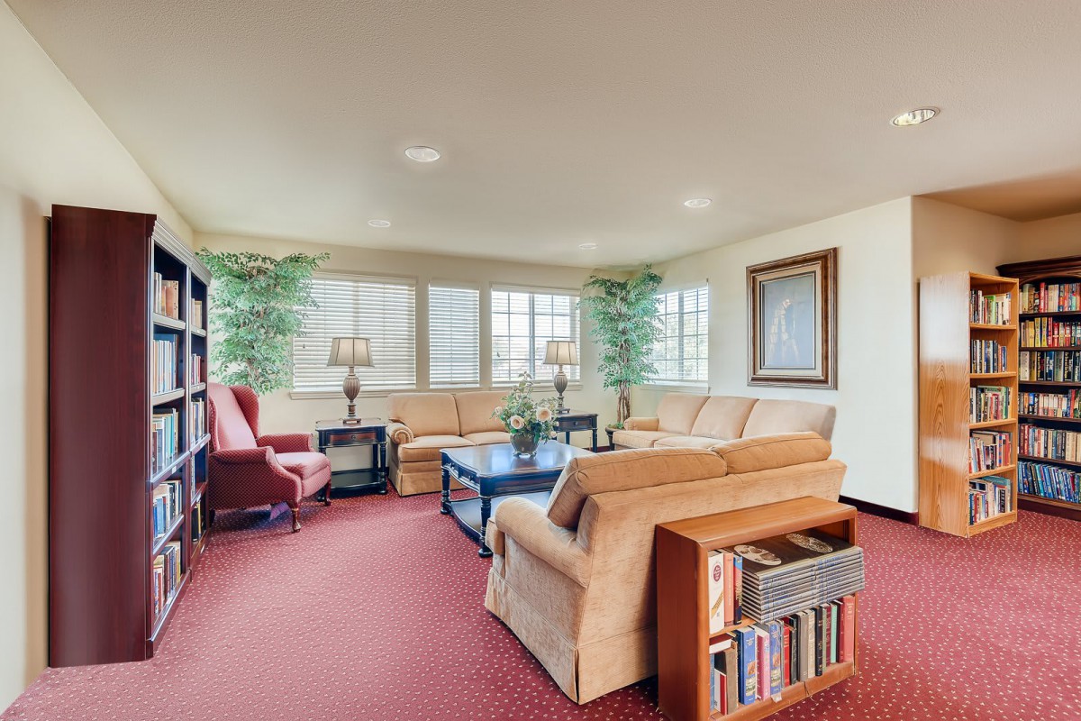 A cozy living room with comfortable seating, bookshelves, and decor.