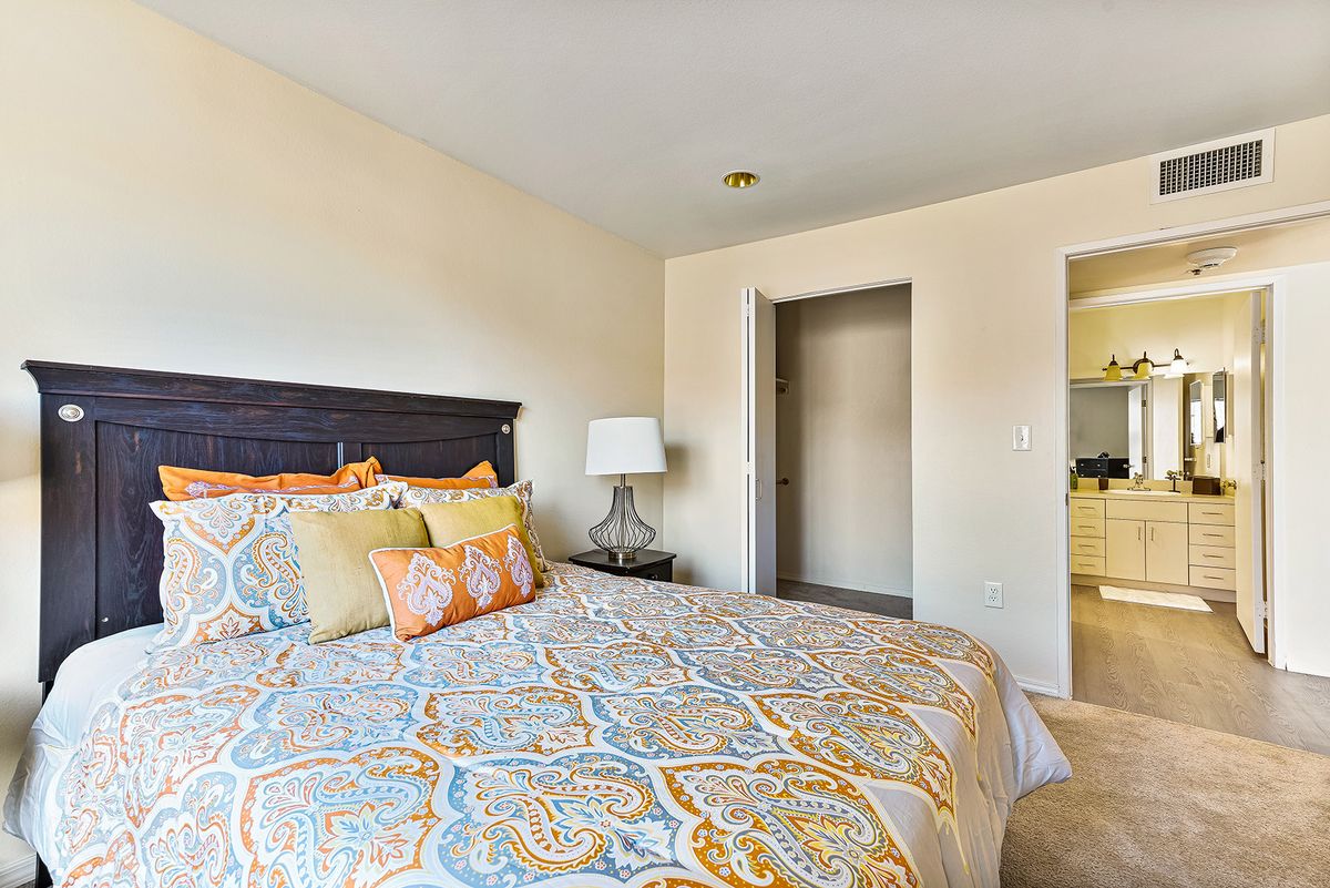 A cozy bedroom with patterned bedding and elegant decor.