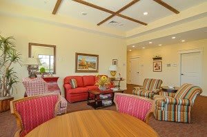 A cozy living room with colorful furniture and artwork on the walls.