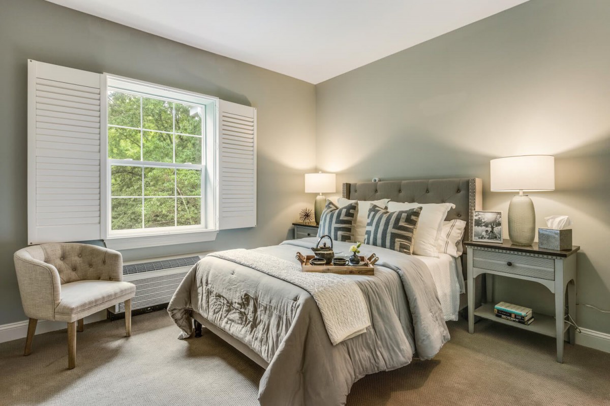 A modern bedroom with neutral tones and elegant decor.