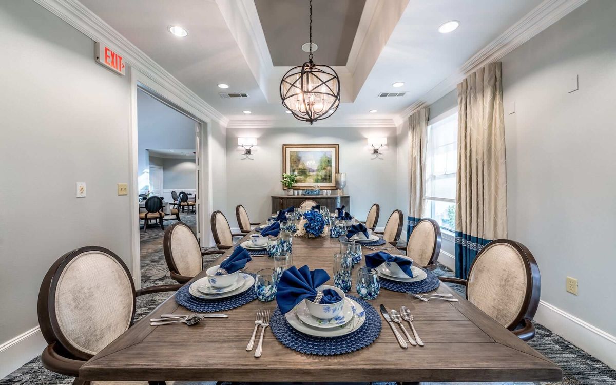 A beautifully set dining table with blue accents in an elegant dining room.