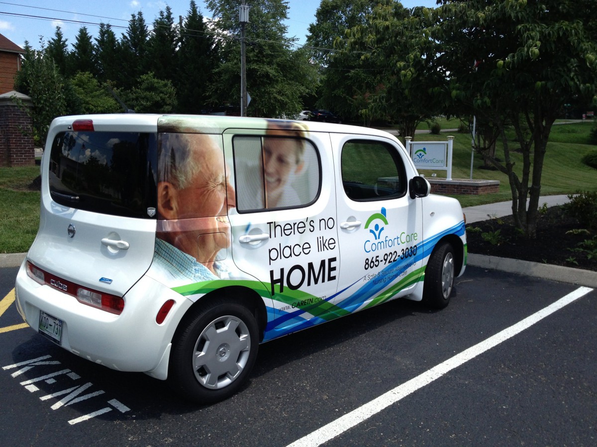 A car with an advertisement wrap promoting home healthcare services.
