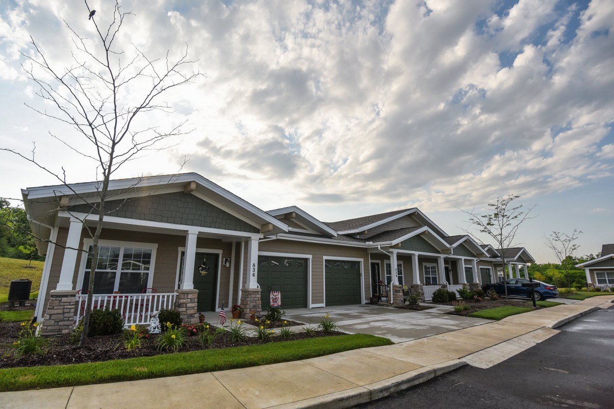 A suburban row of houses under a cloudy sky.