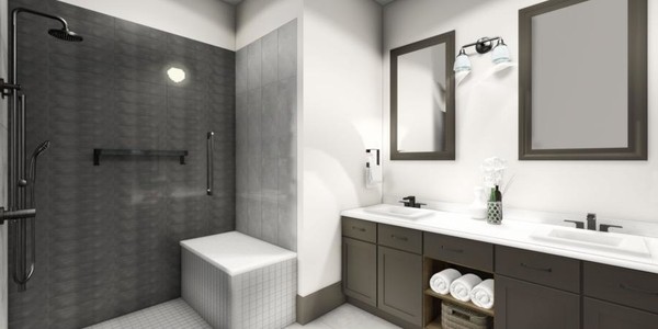 A modern bathroom with a walk-in shower, sink, and neatly arranged towels.