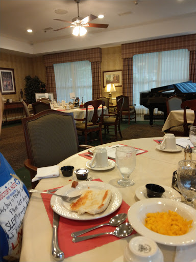 A cozy dining area set for breakfast, featuring a piano and a warm atmosphere.