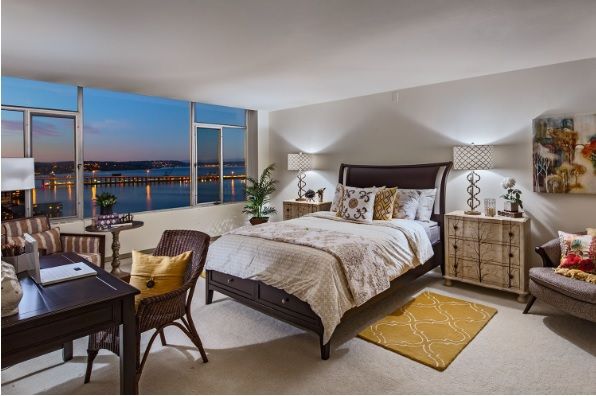 A modern and cozy bedroom with stylish furniture, featuring a stunning nighttime view through the large window.