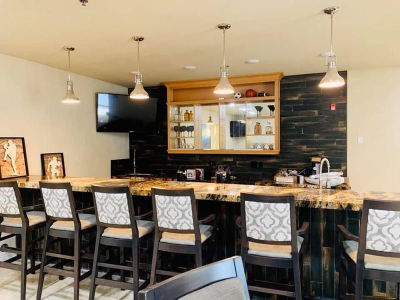 A modern indoor bar area featuring a sleek countertop, stylish seating, and ambient lighting.