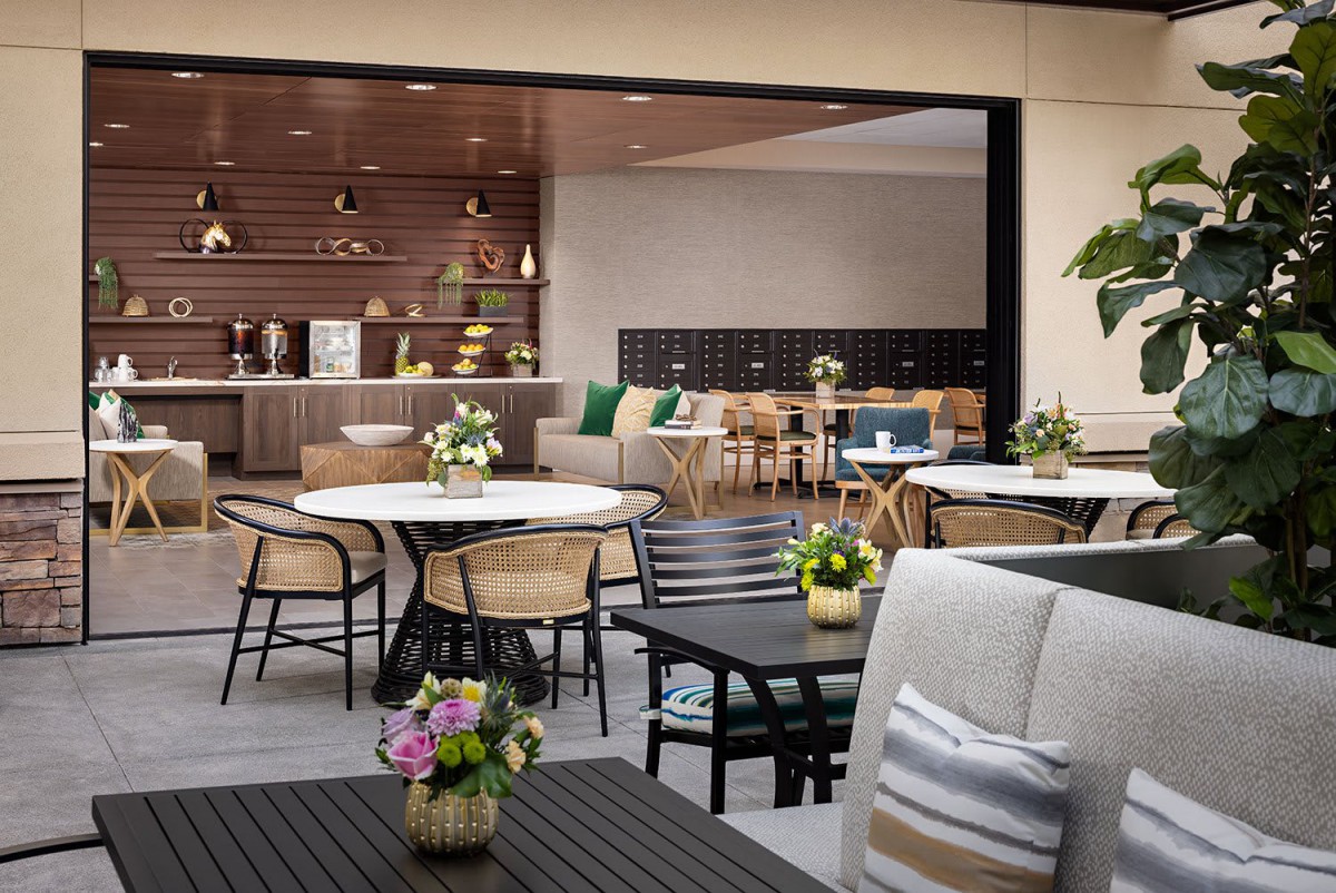 A modern cafe interior with tables, chairs, and floral decorations.