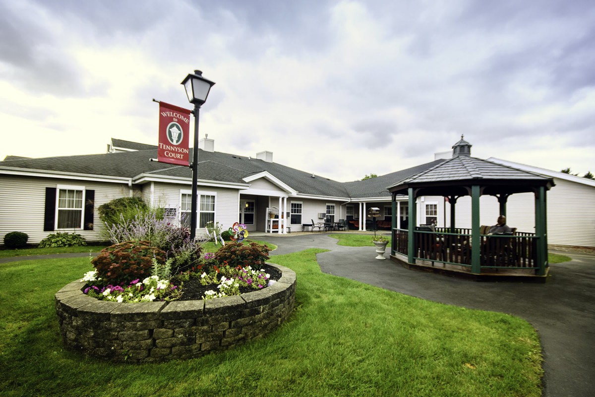 A scenic view of a building with a surrounding garden and gazebo.