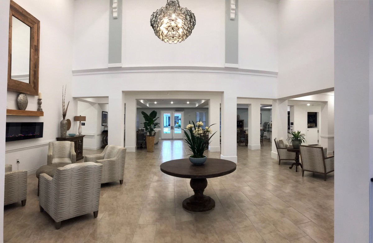 A spacious and elegantly decorated lobby with modern furniture and a striking chandelier.