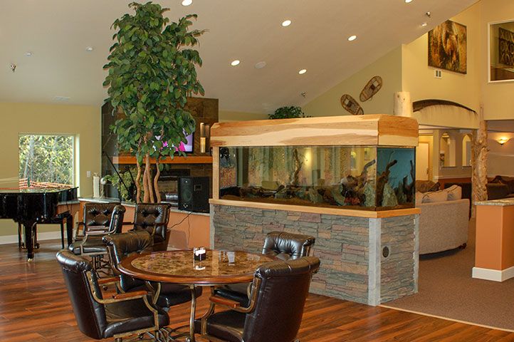A cozy lounge interior featuring a large aquarium and comfortable seating.