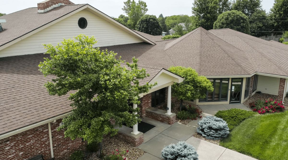 A residential house with landscaped surroundings and a front entrance.