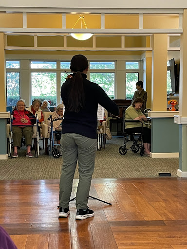 A performer engages with an audience at a community center event.
