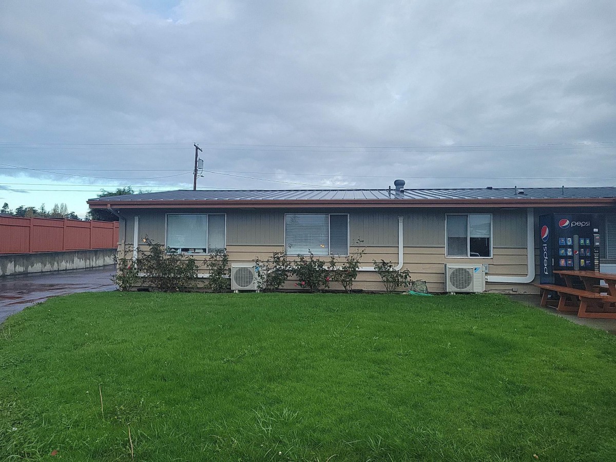 A single-story house with a neatly maintained lawn under a cloudy sky.