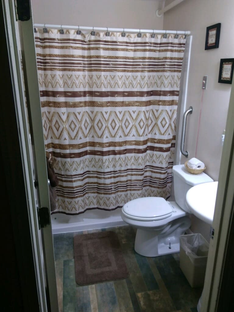 A small bathroom with a patterned shower curtain and basic amenities.