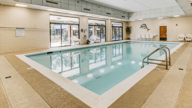 Indoor swimming pool area with large windows and modern design.