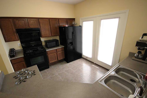 A modern kitchen featuring black appliances and plenty of natural light.