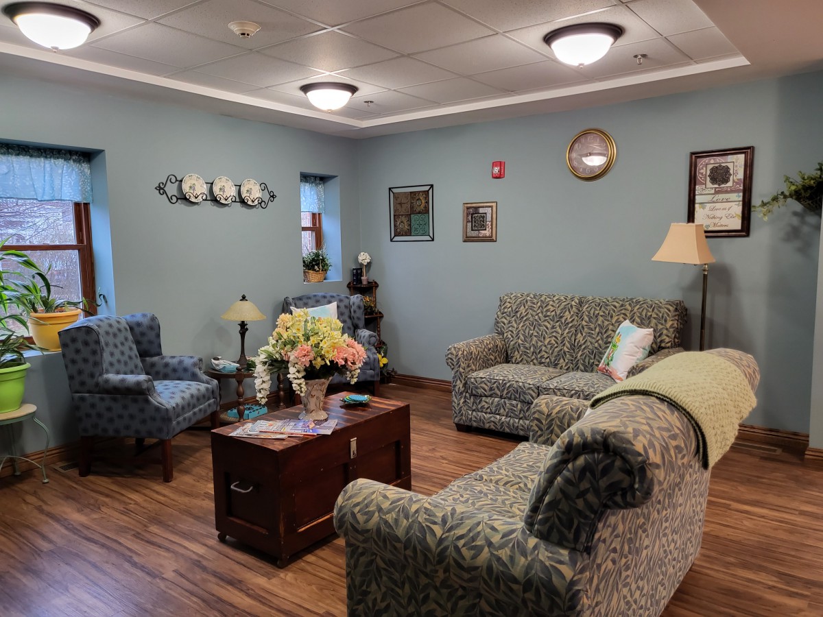 A cozy living room with floral-patterned furniture and various decorative items.
