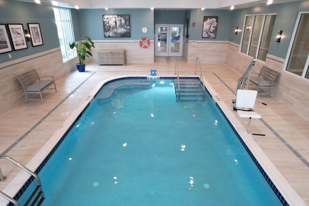 An inviting indoor swimming pool with clean, blue water and tiled surroundings, perfect for relaxation.