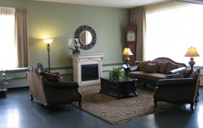A cozy living room with elegant furniture, featuring a fireplace and decorative elements.