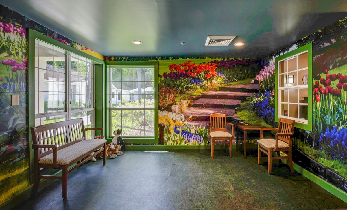 A room with a vibrant mural depicting a garden path, featuring seating and large windows.
