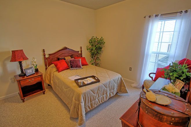 A cozy bedroom with a neatly made bed, warm lighting, and tasteful decor.