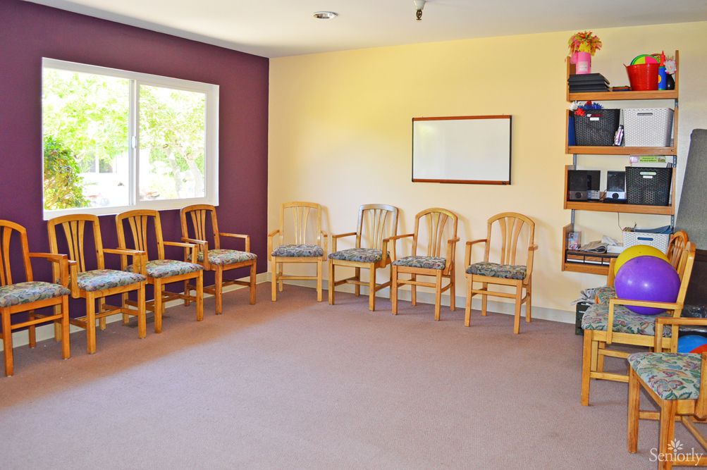 An empty waiting room with arranged chairs and a window.