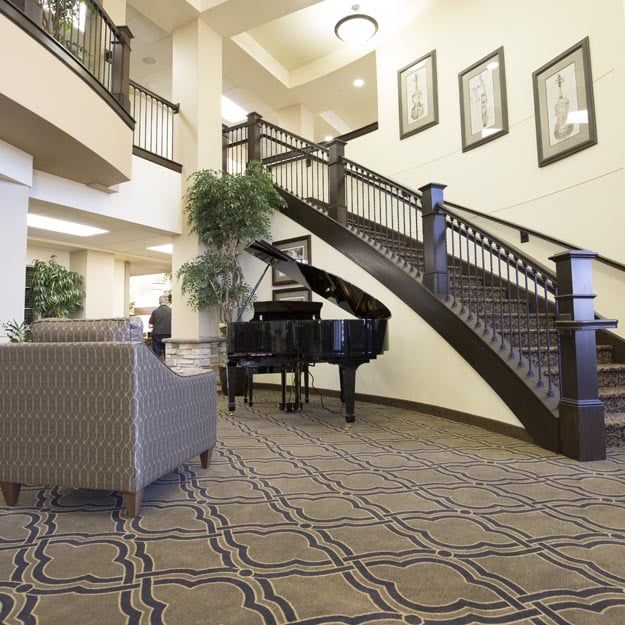 Elegant lobby with a grand staircase and piano.