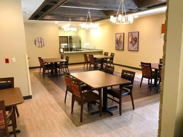 An empty restaurant dining area with neatly arranged tables and chairs.