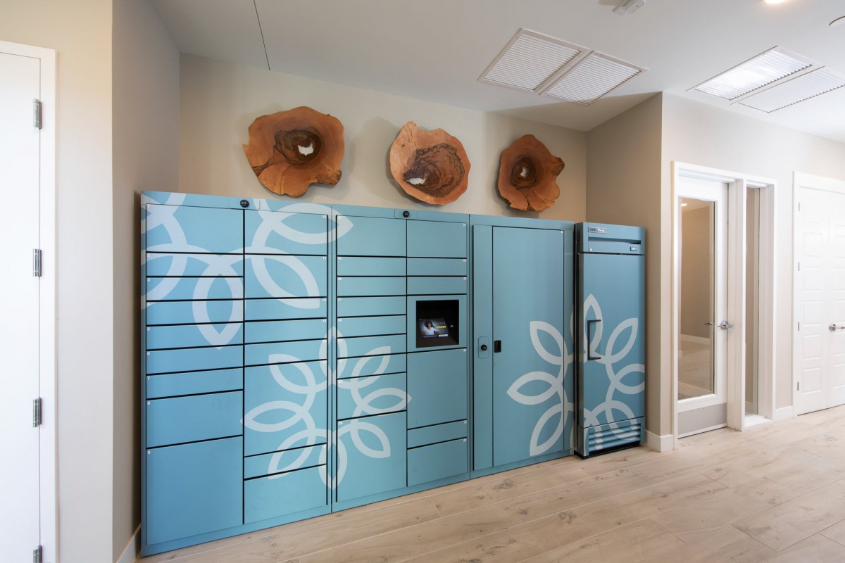 A modern indoor locker system for package pickup, featuring blue panels with floral designs.
