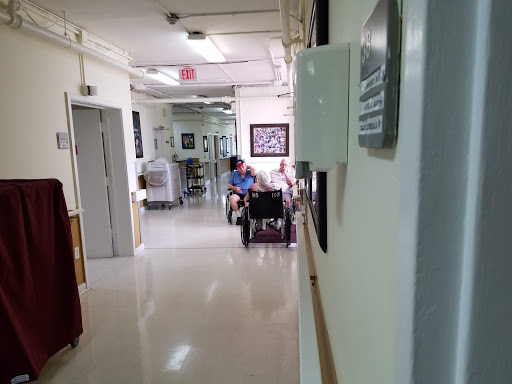 A glimpse into a hospital hallway showing patients seated and the clinical environment.