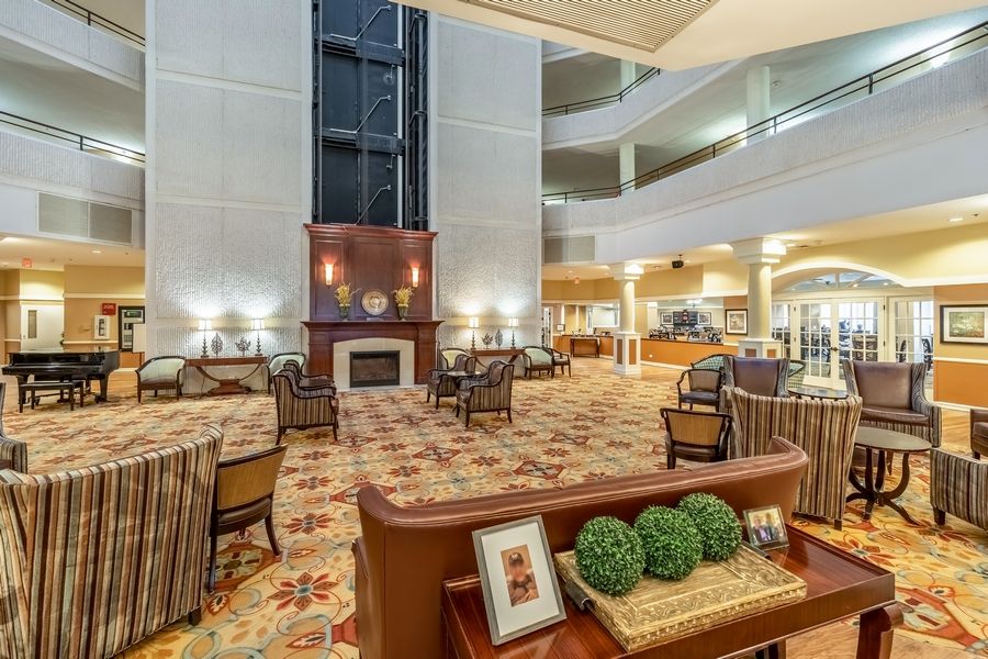 A modern hotel lobby with comfortable seating and a fireplace.