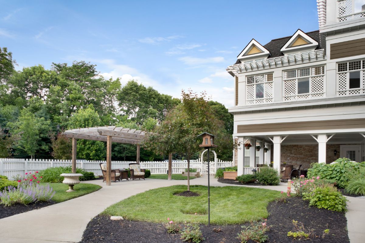 A charming house with a beautifully landscaped garden and a pathway leading to a cozy patio.