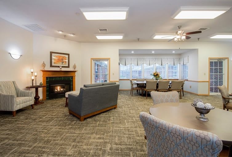 A modern living and dining area featuring a cozy fireplace, comfortable seating, and a well-lit dining table.
