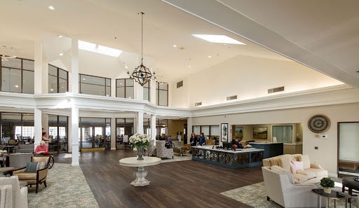 A spacious and elegantly designed interior lobby featuring a chandelier and modern furnishings.