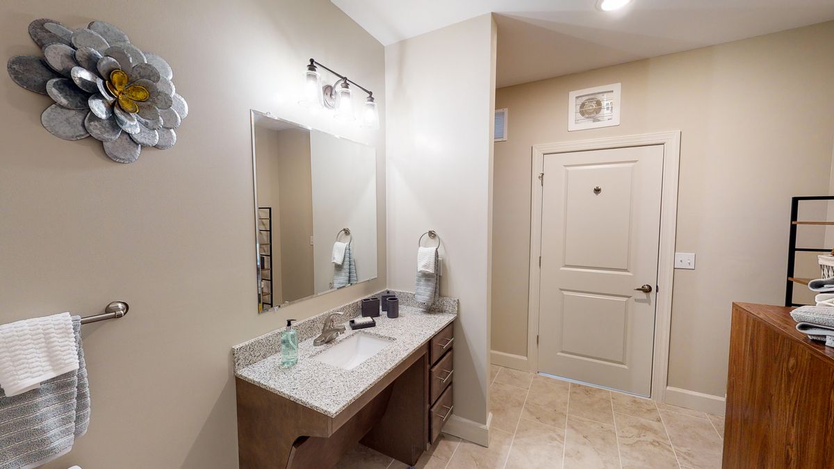 A modern bathroom with a vanity, mirror, and sink.