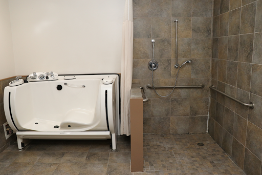 An accessible bathroom featuring a walk-in bathtub and a barrier-free shower area.