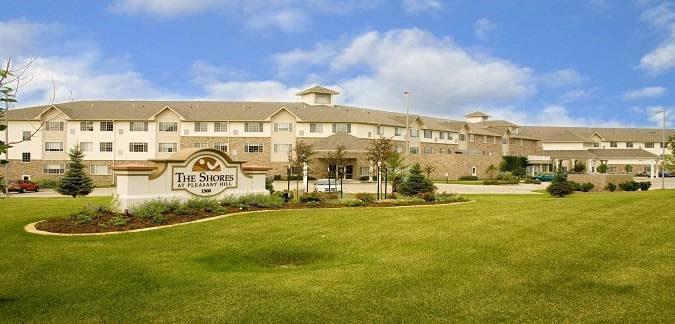 A hotel building with a welcoming entrance and well-maintained landscaping under a partly cloudy sky.