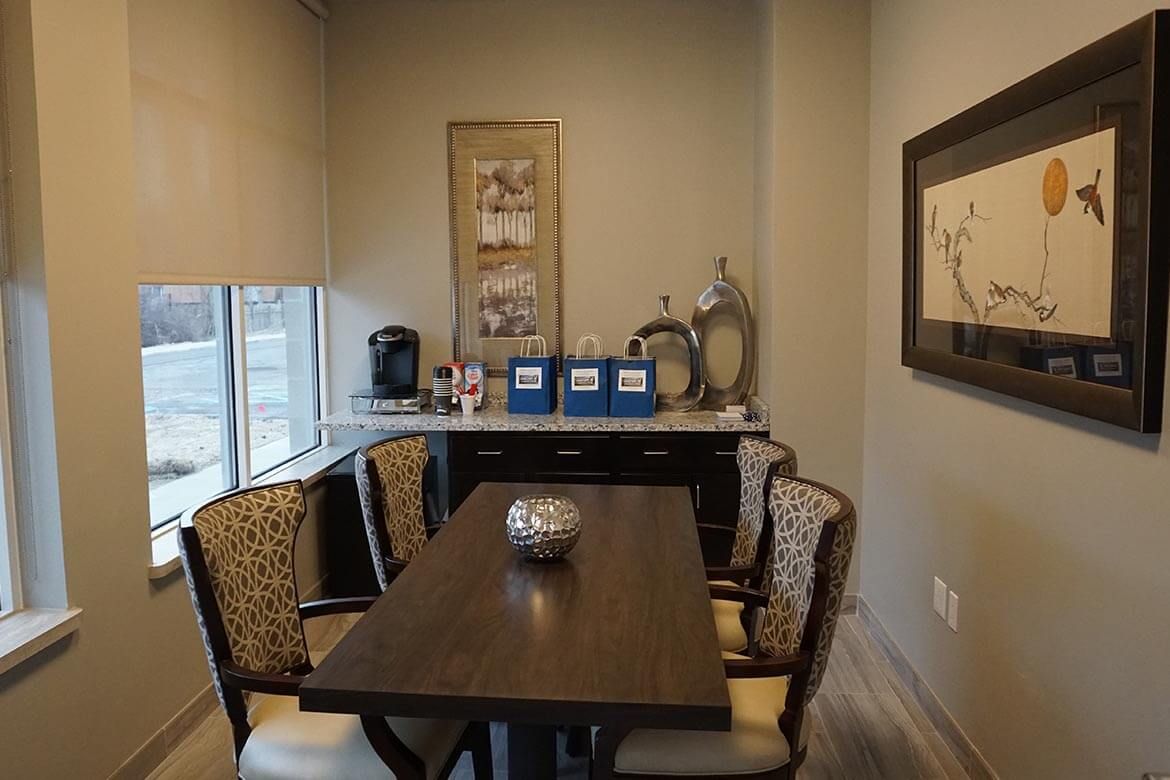A cozy dining area with a wooden table, upholstered chairs, and decorative wall art.