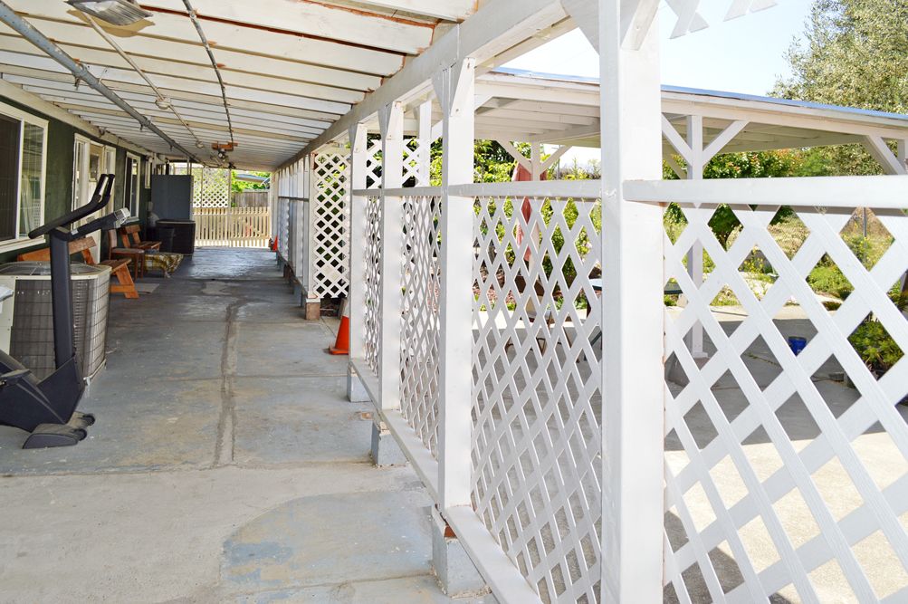 A white lattice carport structure providing shade and shelter.