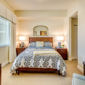 A cozy and well-decorated bedroom with a patterned bedspread and ambient lighting.
