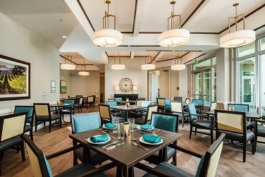 An elegant and modern restaurant dining area with stylish chandeliers and a neatly arranged table setting.