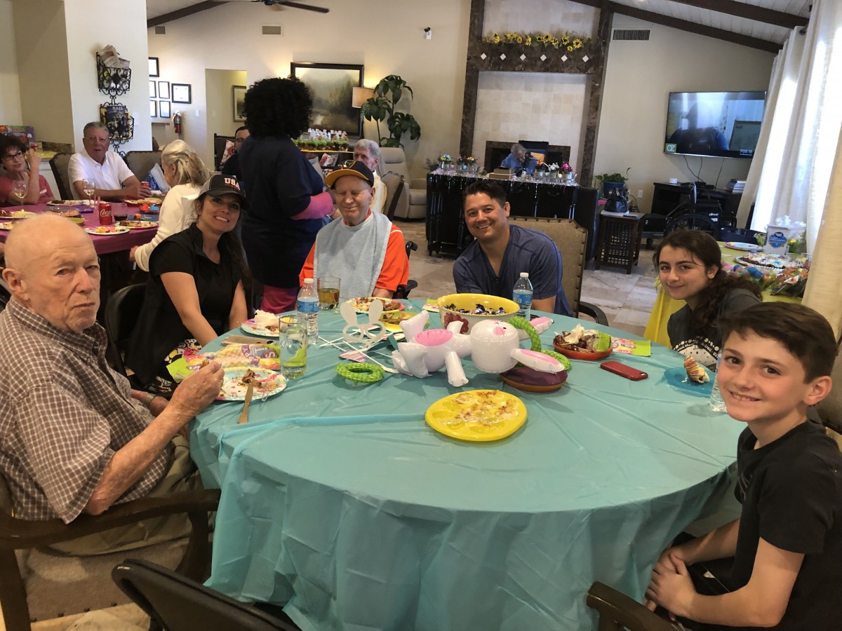 A group of people enjoying a meal together indoors around a table.