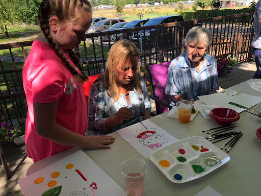 A joyful outdoor painting session where children and adults come together to create art.