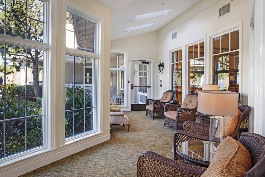 A cozy sunroom with wicker chairs and large windows allowing natural light to flood the space.