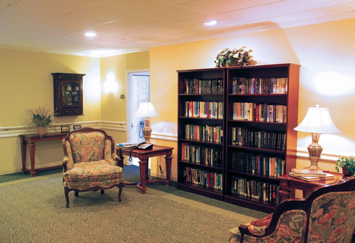 A cozy reading room with a bookshelf and classic furniture.