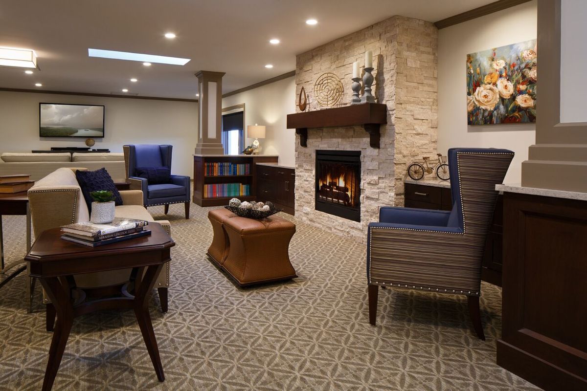 A cozy living room featuring a stone fireplace, comfortable seating, and elegant decor.