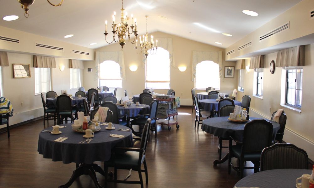 Elegant dining room with chandeliers and neatly arranged tables.