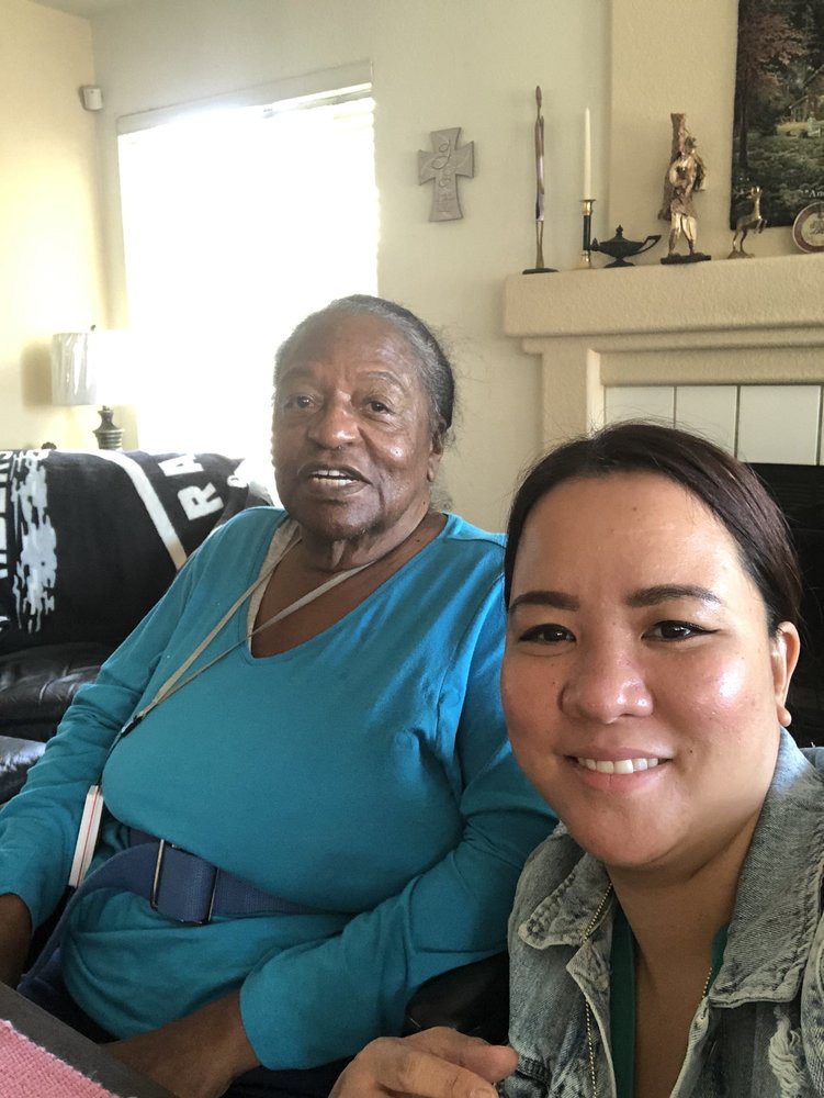 Two people smiling for a selfie in a cozy living room.